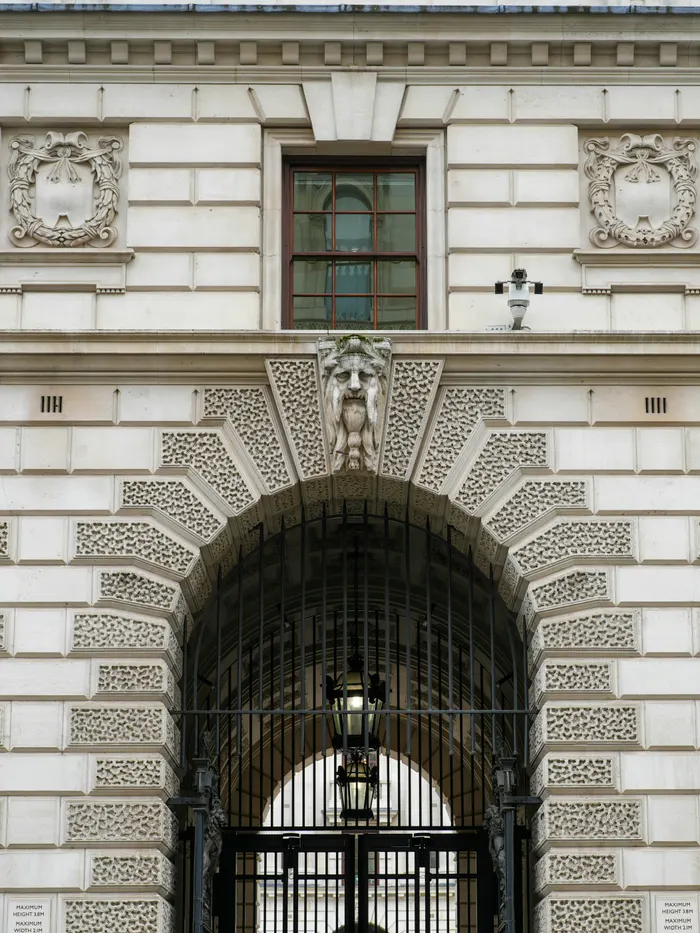 The stone facade and arched gate of a classical bank building.